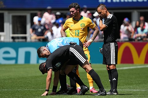 Referee Felix Zwayer, of Germany, gets medical advice during the World Cup Group D soccer match between the United States and Australia in Seattle, Friday, June 19, 2026.