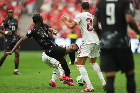 Canada's Ismael Kone, left, falls while being fouled against by Qatar's Assim Madibo during the World Cup Group B soccer match in Vancouver, British Columbia, Thursday, June 18, 2026.