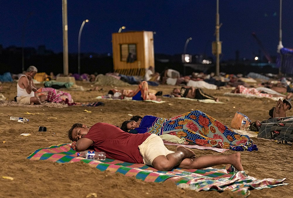 People sleep on Versova Beach