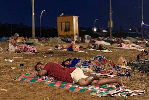 Residents from nearby slum settlements sleep on Versova Beach amid intense heatwave and frequent power outages, in Mumbai, Maharashtra.