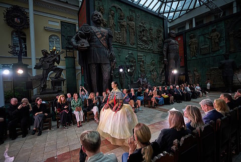 A model wears a creation during the final show for graduates of the Costume Design and Art Fashion bachelor's degrees of the Institute of Business and Design B&D at the Tsereteli Art Gallery, backdropped by a statue of Russian Czar Alexander II, center left, in Moscow.