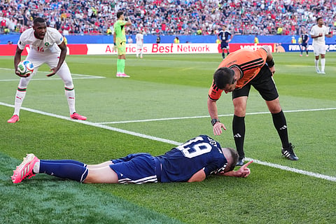 Referee Ilgiz Tantashev, right, checks on Scotland's Lewis Ferguson during the World Cup Group C soccer match between Scotland and Morocco in Foxborough, Mass., near Boston, Friday, June 19, 2026.
