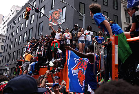 New York Knicks fans celebrate the team's NBA championship following a ticker-tape parade down Lower Manhattan's "Canyon of Heroes" on Broadway, in New York.