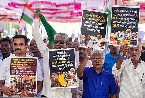 People hold placards during a protest against the Special Intensive Revision (SIR) of electoral rolls, in Bengaluru, Karnataka.