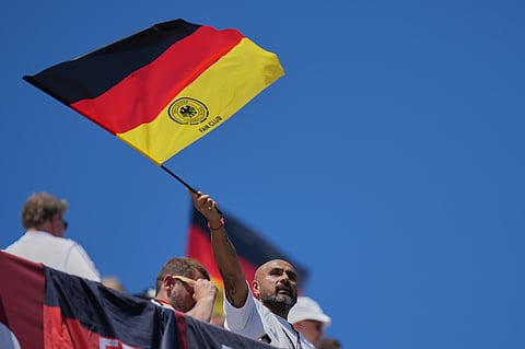 A German fan waves flag as he looks on from the stands ahead of the World Cup Group E soccer match between Germany and Ivory