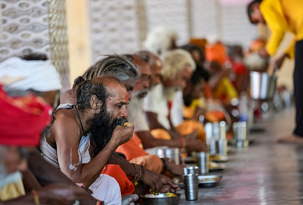 Sadhus eat food at Ram Mandir base camp
