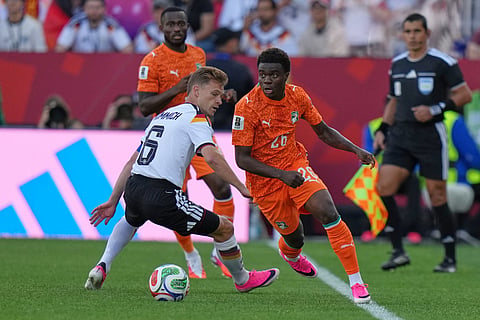 Germany's Joshua Kimmich, left, vies for the ball with Ivory Coast's Christ Inao Oulai during the World Cup Group E soccer match