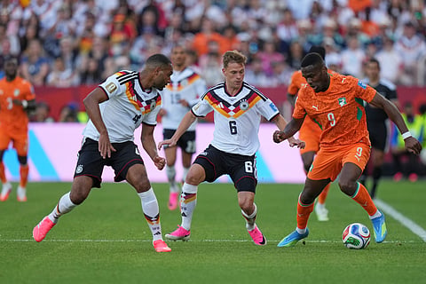 Germany's Jonathan Tah, left, with Germany's Joshua Kimmich centre, challenge Ivory Coast's Ange-Yoan Bonny 