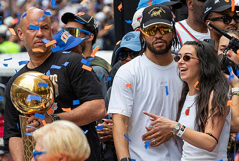 New York Knicks guard Jalen Brunson, center, wife Ali Brunson, along with Jalen Brunson's father Rick, at left, are in the NBA championship ticker-tape parade on Broadway, in New York's "Canyon of Heroes,". 