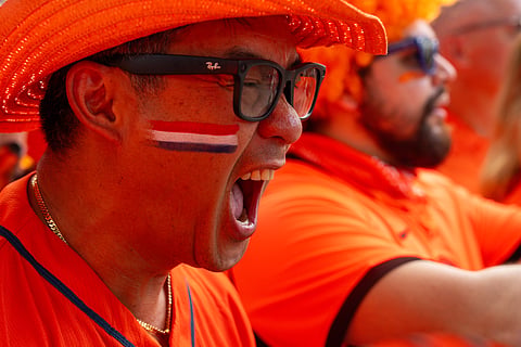 Nguyen Le cheers before Netherlands fans take part in an "Orange Walk" to Houston Stadium before a FIFA World Cup Group F soccer match between Netherlands and Sweden in Houston.