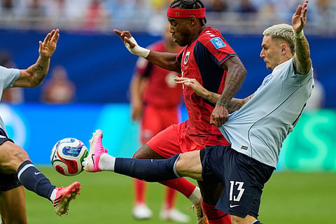 Cape Verde's Garry Rodrigues (11) and Uruguay's Guillermo Varela (13) battle for the ball during the World Cup Group H match.