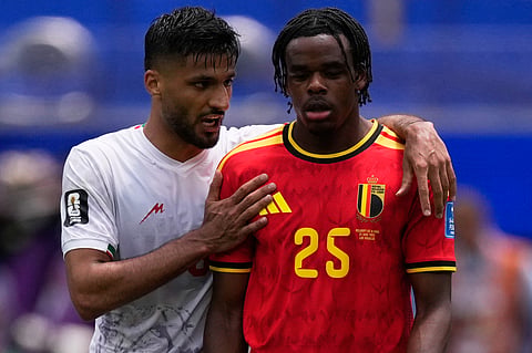 Iran's Mohammad Mohebbi, left, embraces Belgium's Nathan Ngoy at the end of the first half of the World Cup Group G