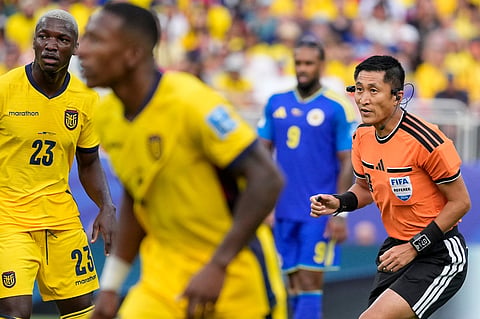 Referee Ma Ning, of China, looks on during the World Cup Group E soccer match between Ecuador and Curacao in Kansas City
