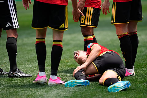 Belgium's Leandro Trossard grimaces in pain during the World Cup Group G soccer match against Iran in Inglewood, Calif