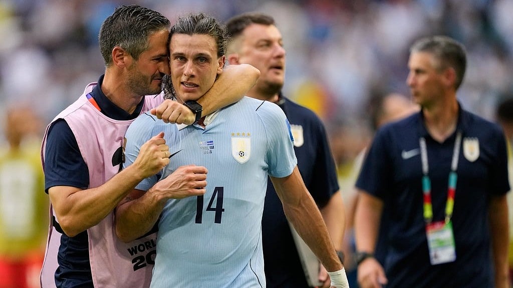 Uruguay's Agustin Canobbio (14) is congratulated by a team official after scoring his team's second goal during the World Cup Group H soccer match between Uruguay and Cape Verde in Miami Garden. - Rebecca Blackwell/AP Photo