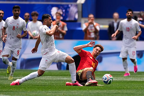 Iran's Mehdi Taremi, left, and Belgium's Thomas Meunier fight for the ball during the World Cup Group G soccer match