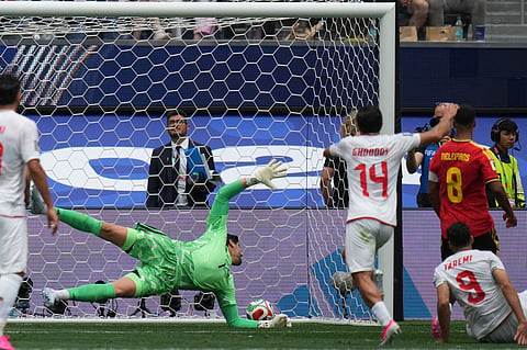 Belgium goalkeeper Thibaut Courtois, center, fails to stop a shot by Iran's Mehdi Taremi disallowed for offside.