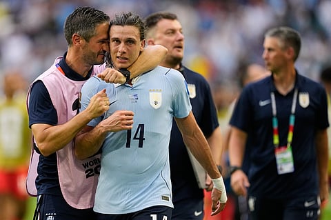 Uruguay's Agustin Canobbio (14) is congratulated by a team official after scoring his team's second goal during the World Cup Group H soccer match between Uruguay and Cape Verde in Miami Garden