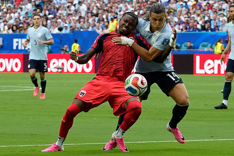 Cape Verde's Sidny Lopes Cabral, left, and Uruguay's Agustin Canobbio fight for the ball during the World Cup Group H soccer match.