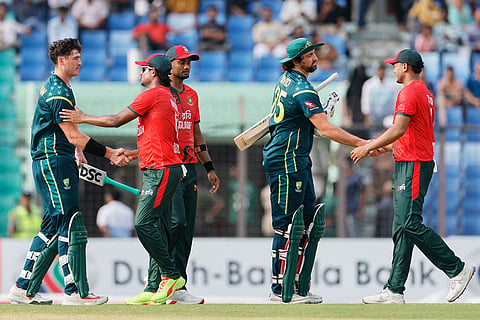 Bangladesh's players congratulate Australia's Tim David, center, and Matt Renshaw, left, after Australia won the third T20 international cricket match between Australia and Bangladesh, in Chattogram, Bangladesh.