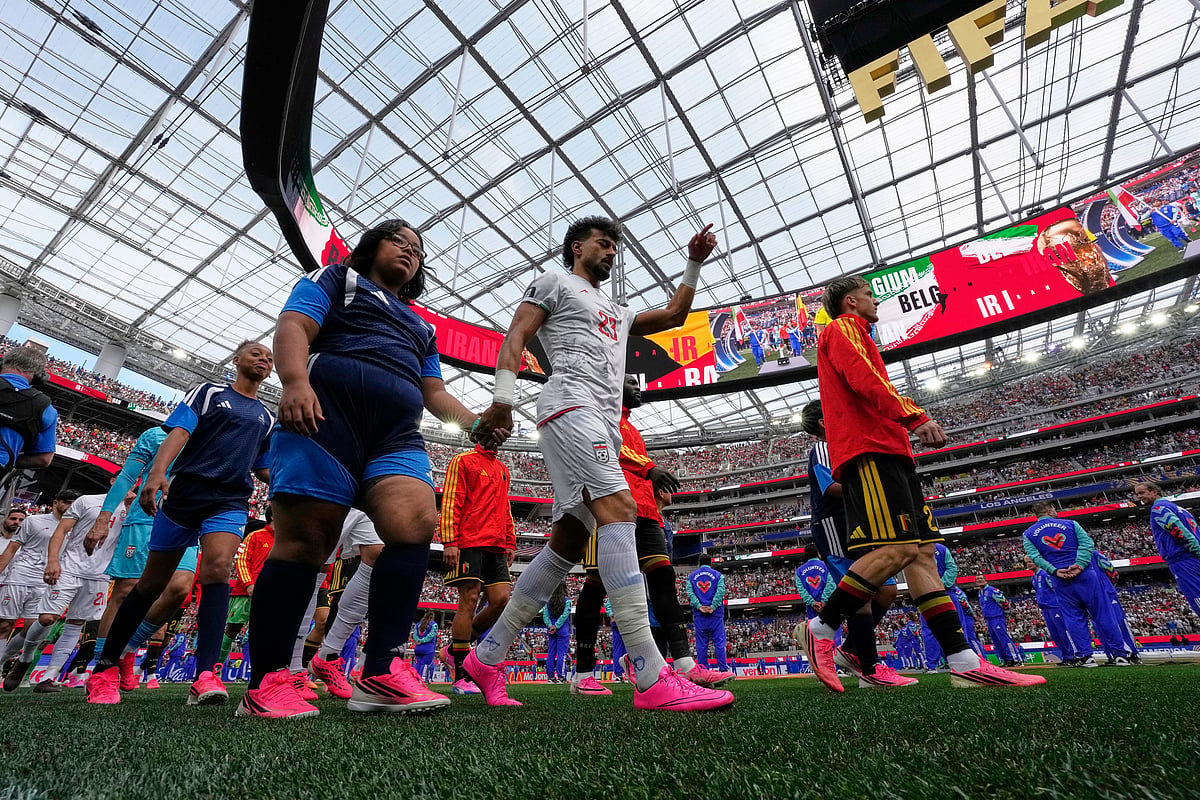 Iran and Belgium players walk out onto the pitch ahead of their match. - AP/Gregory Bull