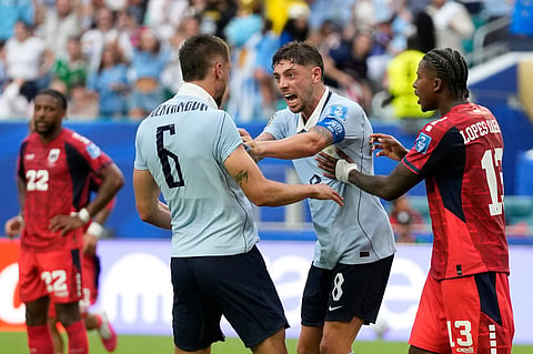 Uruguay's Federico Valverde, center right, and Rodrigo Bentancur celebrate the first goal by their teammate Maxi Araujo during the World Cup Group H soccer match between Uruguay and Cape Verde in Miami Gardens