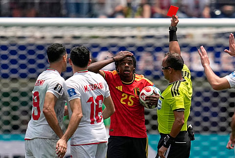 Referee Dario Herrera, right, shows a red card to Belgium's Nathan Ngoy (25), center, during the World Cup Group G soccer match between Belgium and Iran in Inglewood, California, near Los Angeles.