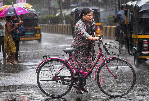 A woman makes her way amid rainfall, in Mumbai, Maharashtra.