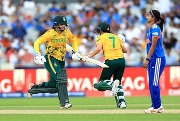 | Photo: Nigel French/PA via AP : South Africa's Chloe Tryon (left) and Marizanne Kapp score the winning runs as India players look on during the ICC Women's T20 World Cup match between India and South Africa, at Emirates Old Trafford, Manchester, England.