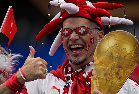 A fan of Switzerland holds a replica of a World Cup trophy ahead the World Cup Group B soccer match between Switzerland and Bosnia in Inglewood, Calif, near Los Angeles, Thursday, June 18, 2026.