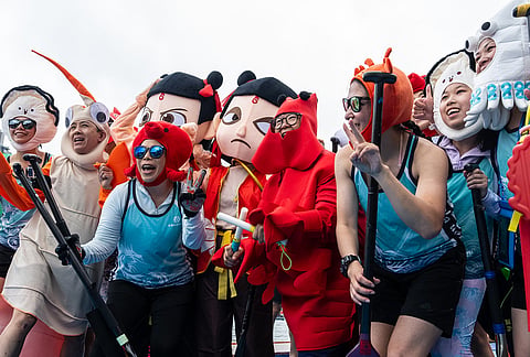 Competitors in costumes pose for photographs before the Aberdeen Dragon Boat Race to celebrate the Dragon Boat Festival in Hong Kong.