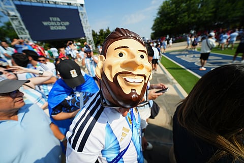 An Argentina fan wears a mask of Argentina's Lionel Messi outside the stadium