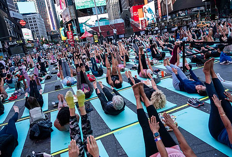 People participate in a mass yoga class during the "Times Square: Mind Over Madness Yoga" event, to celebrate the summer solstice, in New York. 