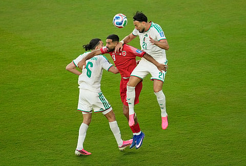 Jordan's Ali Olwan, center, competes for the ball against Algeria's Ramiz Zerrouki, left, and Ramy Bensebaini during the World Cup Group J soccer match between Jordan and Algeria in Santa Clara, Calif., near San Francisco.
