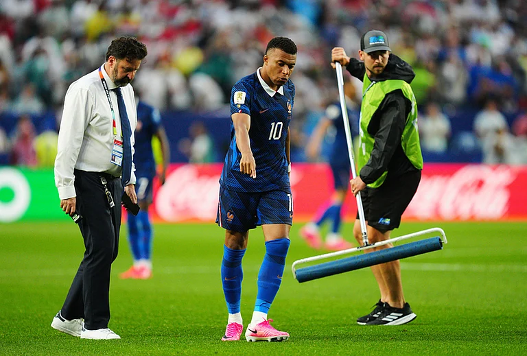 France's Kylian Mbappe (10) directs Ground staff where to squeegee water from the pitch following a weather delay in the World Cup Group I soccer match between France and Iraq in Philadelphia. - | Photo: AP/Derik Hamilton