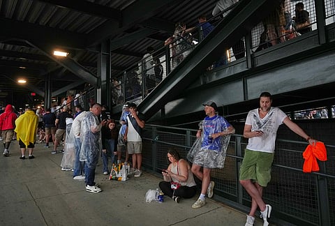 Fans wait in a sheltered area of the stadium as bad weather halts play during the World Cup Group I soccer match between France and Iraq in Philadelphia.