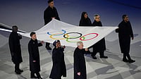 | Photo: AP/Francisco Seco : The Olympic flag is carried by Tadatoshi Akiba, second from right, Rebeca Andrade, Maryam Bukar Hassan, Nicolò Govoni, second from left, Filippo Grandi, Eliud Kipchoge, left, Cindy Ngamba, right, and Pita Taufatofua during the Olympic opening ceremony at the 2026 Winter Olympics, in Milan, Italy.