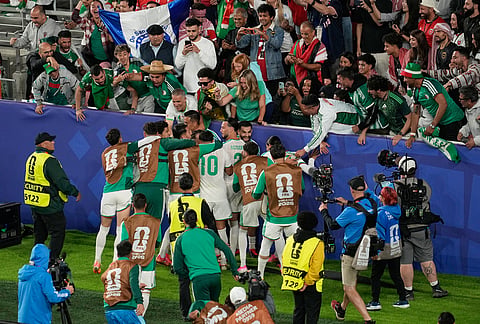 Algeria players celebrate with supporters after Amine Gouiri scored their side's second goal during the World Cup Group J soccer match between Jordan and Algeria in Santa Clara, Calif., near San Francisco.