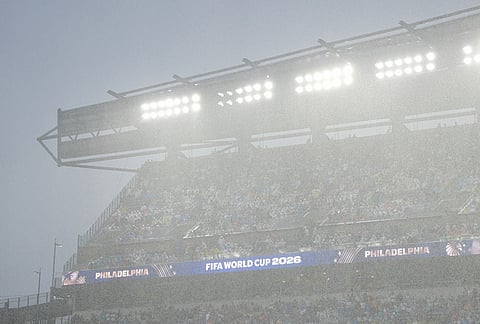 Fans watch the World Cup Group I soccer match between France and Iraq under the rain in Philadelphia.