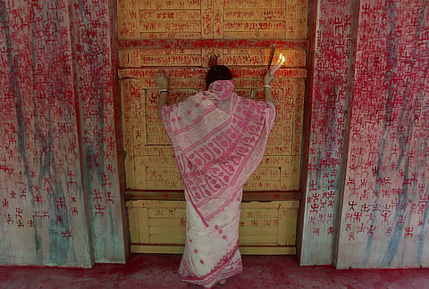 A woman offers prayers on the first day of Ambubachi festival, at a temple, in Agartala, Tripura.