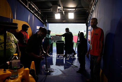 Pitch workers gather in a sheltered area of the stadium during a thunderstorm warning in the World Cup Group I soccer match between France and Iraq in Philadelphia.