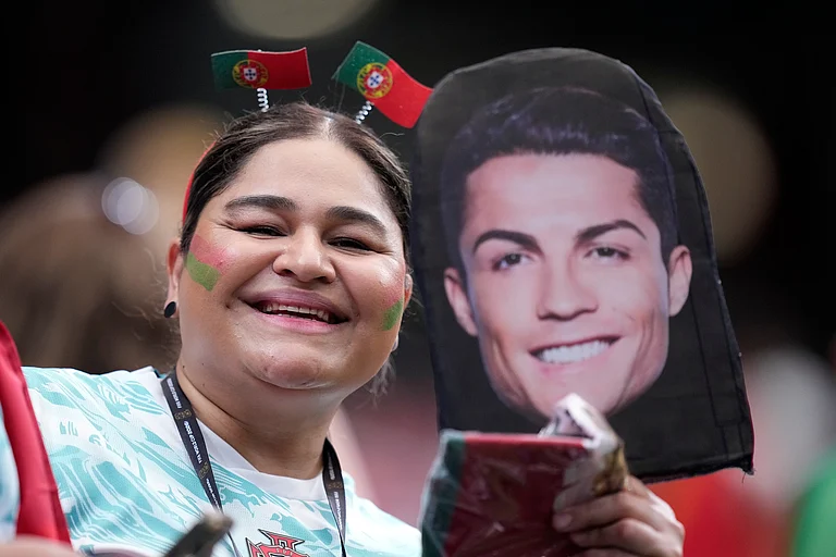 A Portugal fan holds a picture of team captain Cristiano Ronaldo on the stands before the World Cup Group K soccer match - AP/Ashley Landis