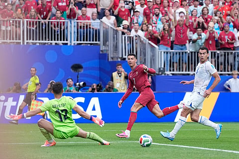 Portugal's Cristiano Ronaldo scores his side's third goal past Uzbekistan goalkeeper Abduvohid Nematov