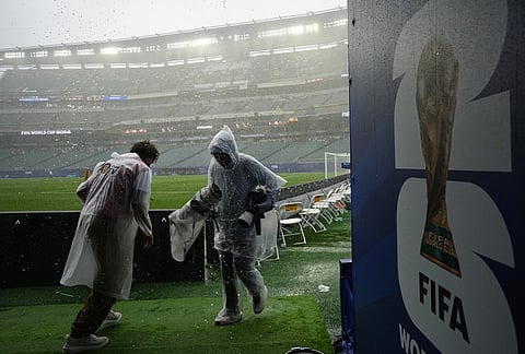 A photographer leaves the field as rain stops play during the World Cup Group I soccer match between France and Iraq in Philadelphia.