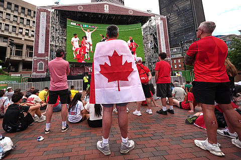Canada fan watch a World Cup soccer game against Switzerland on a giant display at the FIFA Fan Festival, Wednesday, June 24, 2026, in Boston.