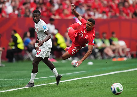 Switzerland's Luca Jaquez (25) is upended by Canada's Richie Laryea (22) during the World Cup Group B soccer match between Switzerland and Canada in Vancouver, British Columbia, Wednesday, June 24, 2026.