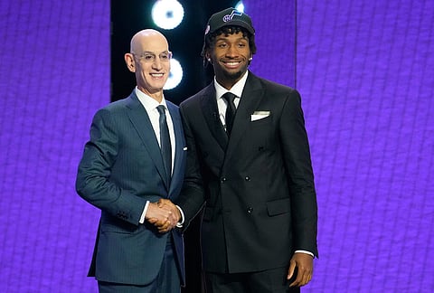 Darryn Peterson, right, poses for a photo with NBA Commissioner Adam Silver, left, after being chosen by the Utah Jazz in the first round of the NBA basketball draft, in New York.