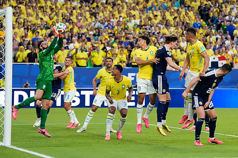 Brazil goalkeeper Alisson Becker, left, stops a shot on goal during the World Cup Group C soccer match between Scotland and Brazil in Miami Gardens, Fla., Wednesday, June 24, 2026.