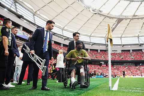 Canada's Ismael Kone, who was injured in a previous match, is helped off the field after watching his teammates warm up before the World Cup Group B soccer match between Switzerland and Canada in Vancouver, British Columbia, Wednesday, June 24, 2026. 