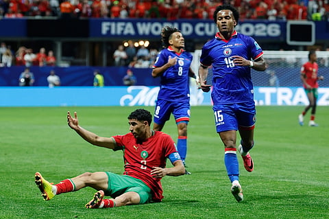 Morocco's Achraf Hakimi (2) reacts after falling as Ruben Providence jogs past during the World Cup Group C soccer match between Morocco and Haiti in Atlanta, Wednesday, June 24, 2026.